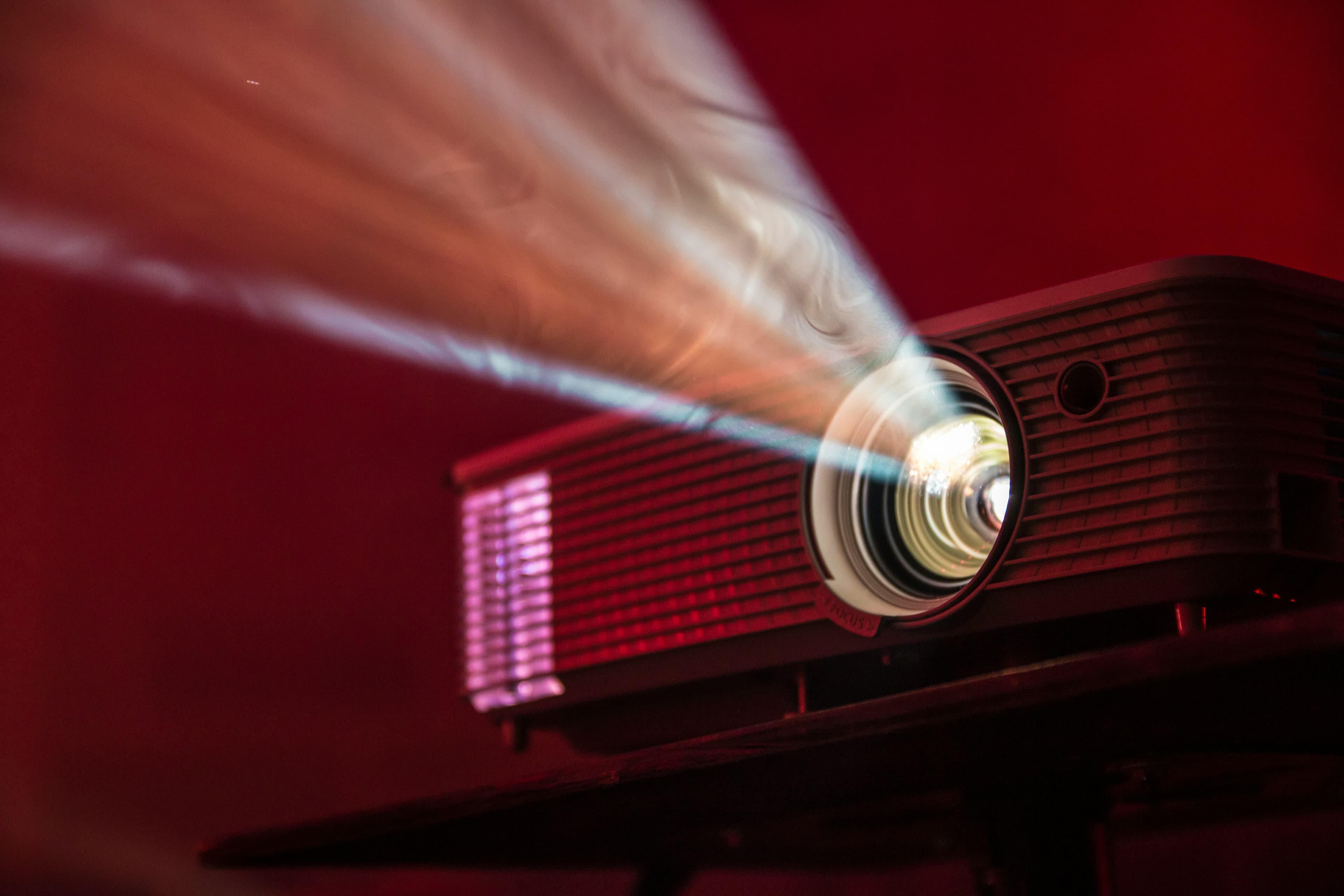 Vintage film projector casting light through smoke